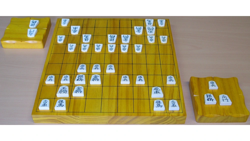 対局途中の将棋盤と左右の駒台に置かれた持ち駒